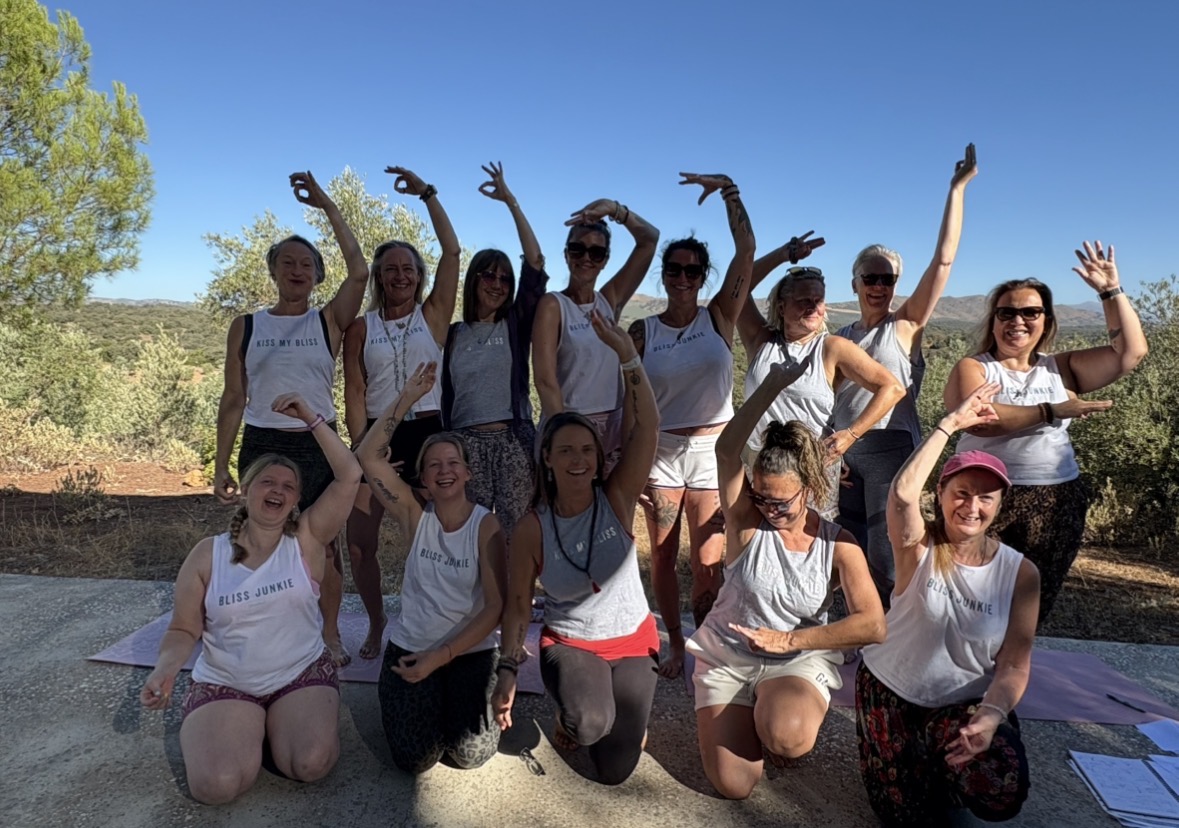 Bliss Junkie yoga retreat group celebrating outdoors in Spanish mountains with matching white vests