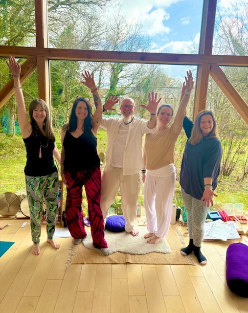 Small retreat group celebrating with arms raised in sunlit glass studio at The Station, Frome