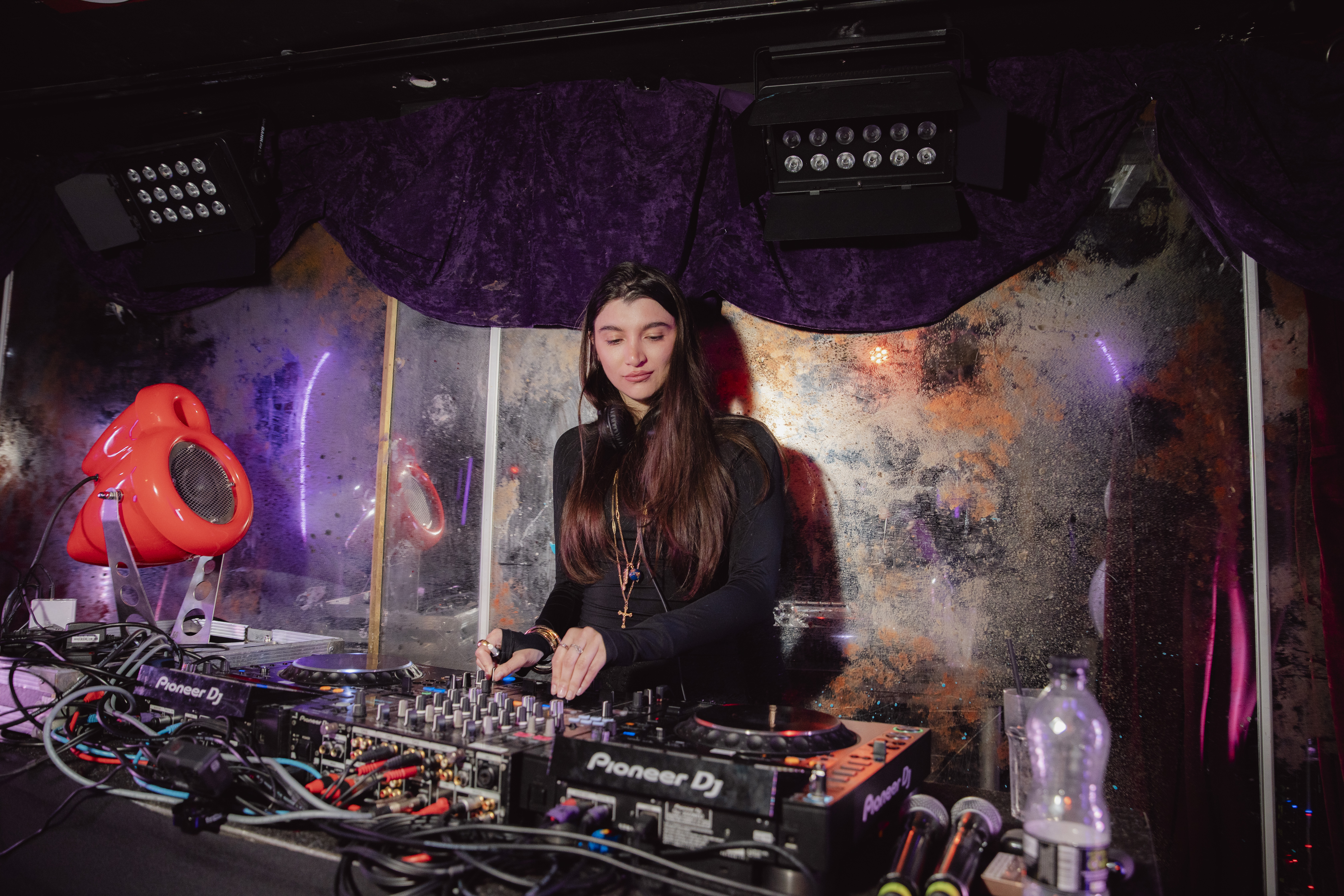 Female DJ performing with red Vesper speaker