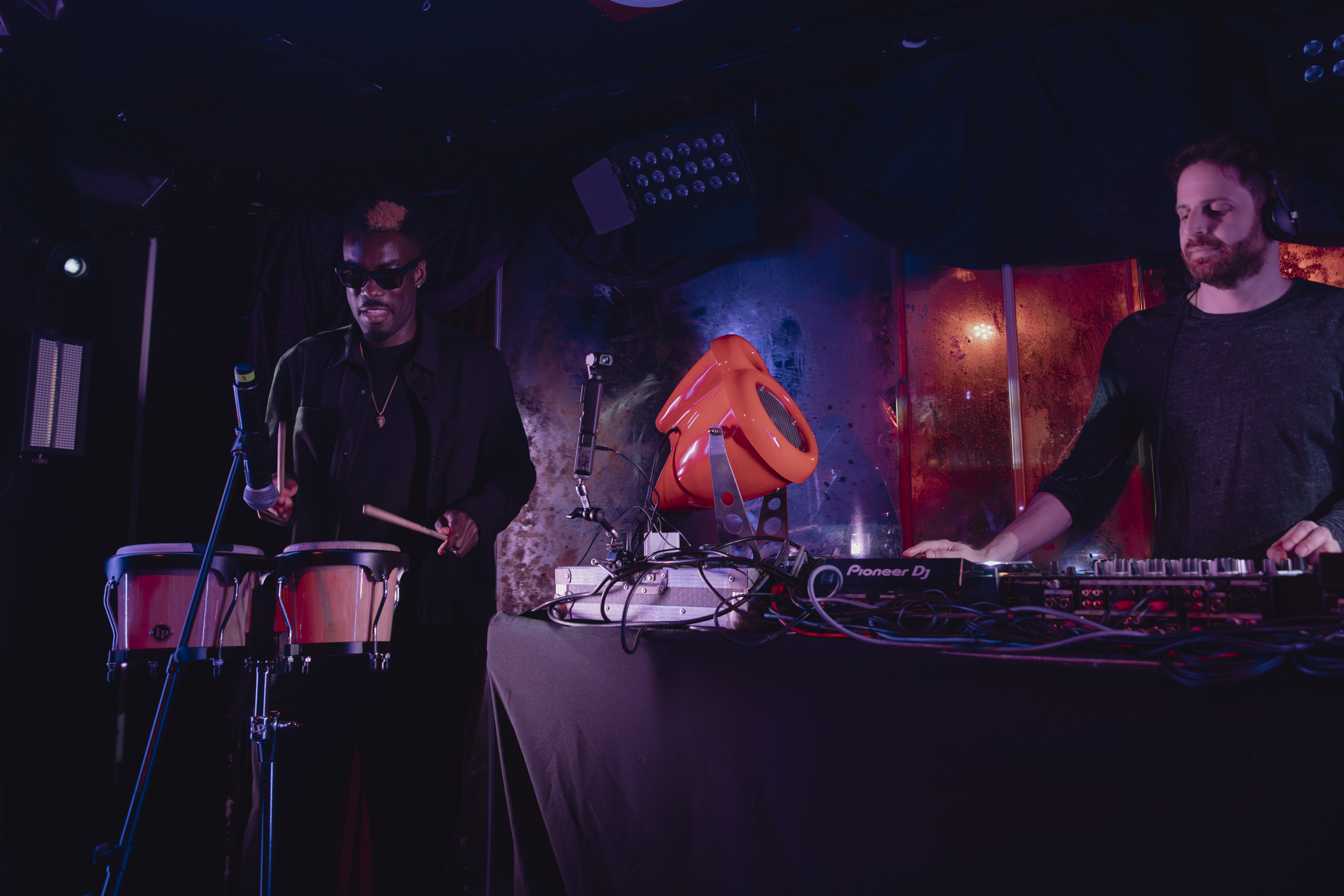 DJ and percussionist performing with red Vesper speaker