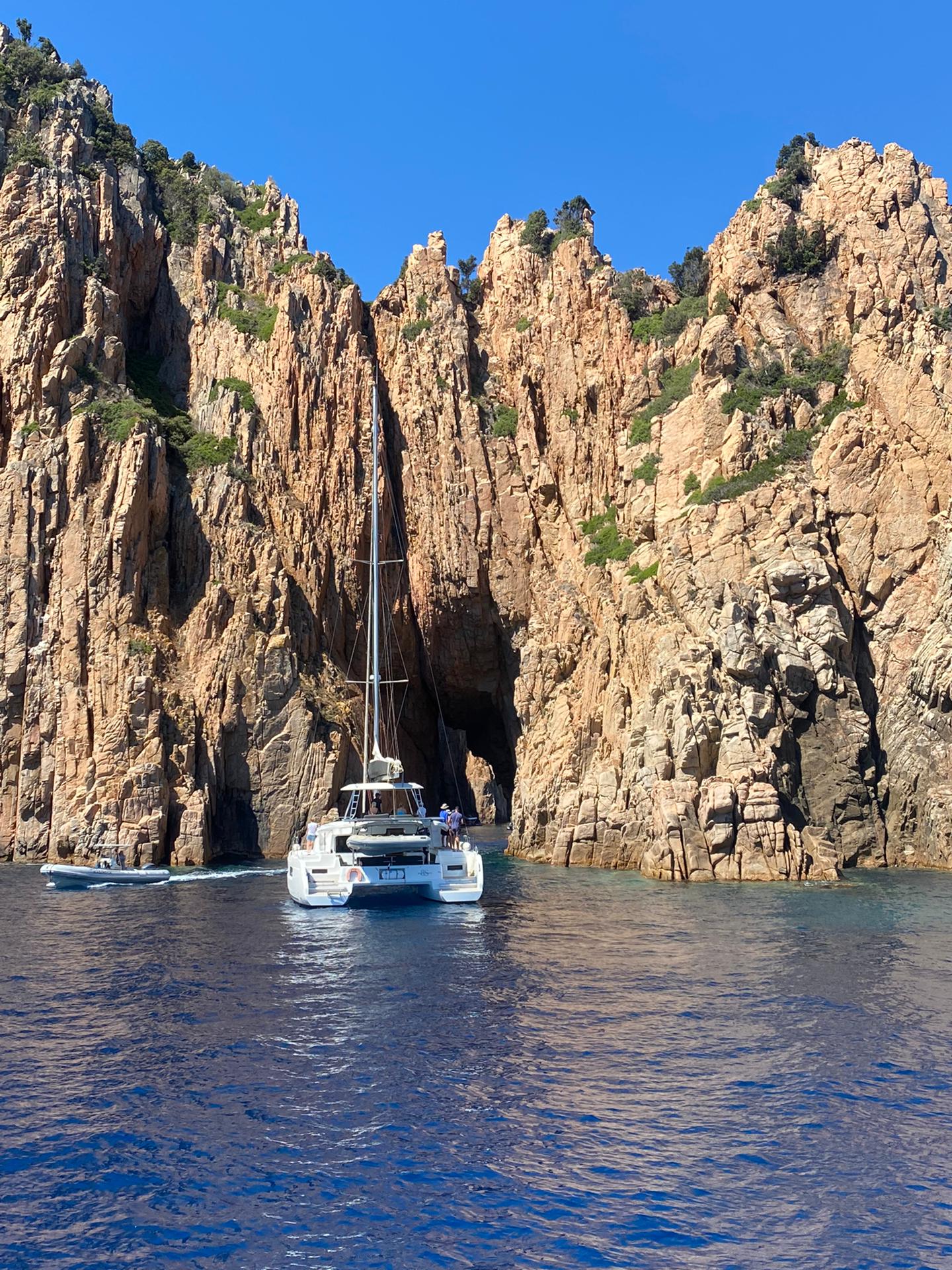 Catamaran SOGNUDIMARE dans les Calanques de Piana (UNESCO) — roches rouges