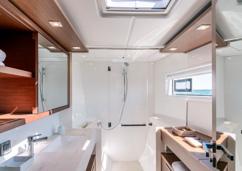 Salle d'eau privative avec douche, hublot et finitions bois noble