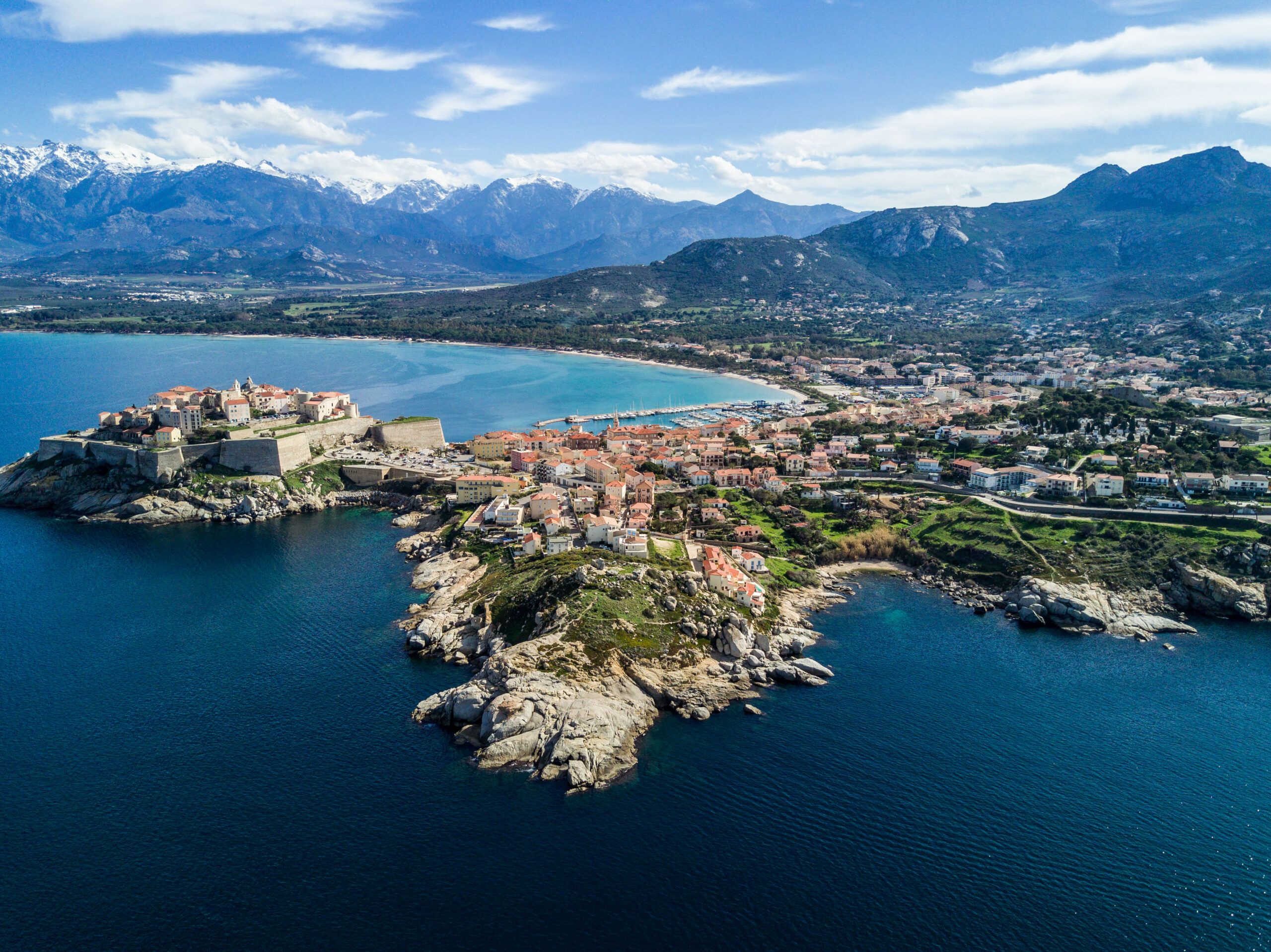 Citadelle de Calvi vue du ciel — montagnes enneigées et baie turquoise