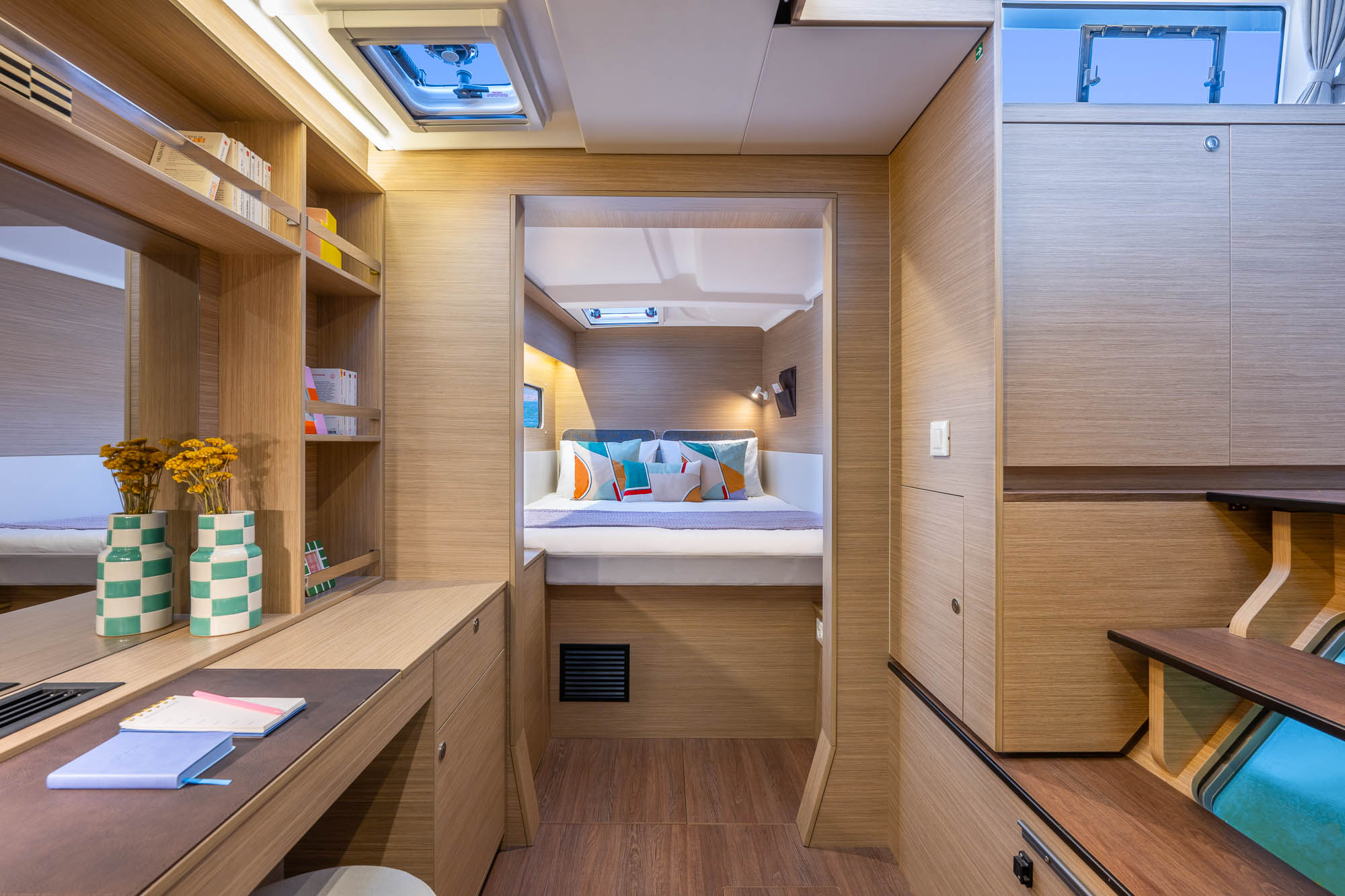 Cabine double catamaran Lagoon — lit confortable et rangements bois clair