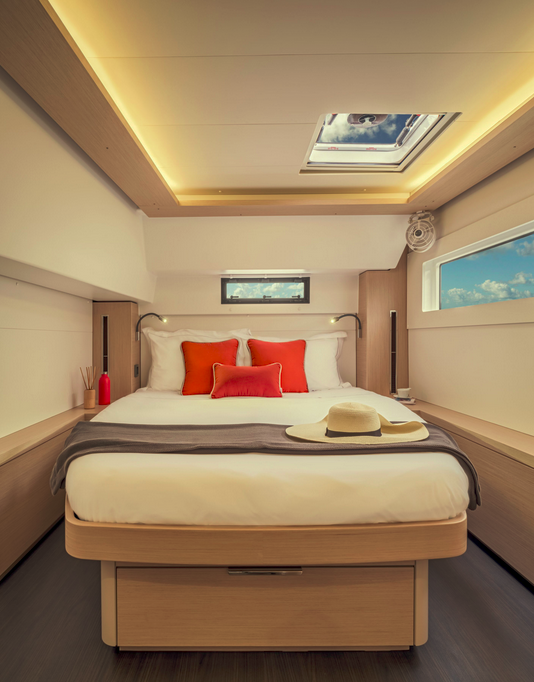 Cabine Master du catamaran — lit king-size, hublots panoramiques, finitions bois clair