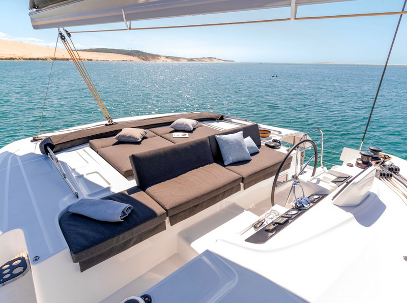 Flybridge du catamaran — salon extérieur avec bains de soleil face à la mer