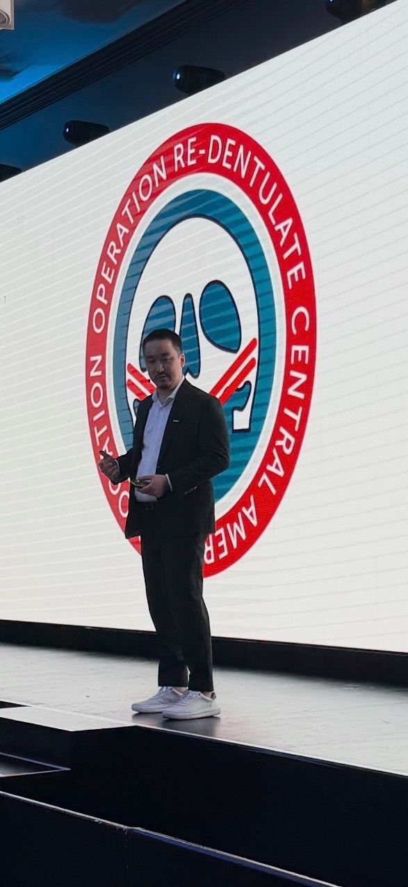 Dr. Simon Oh on stage with the ORCAA logo behind him