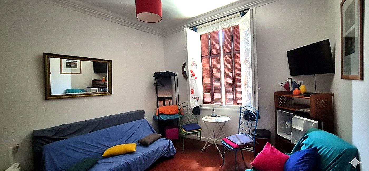 Chambre Double 1 - Bastia Room, espace lumineux avec canapé bleu, fenêtre et télévision