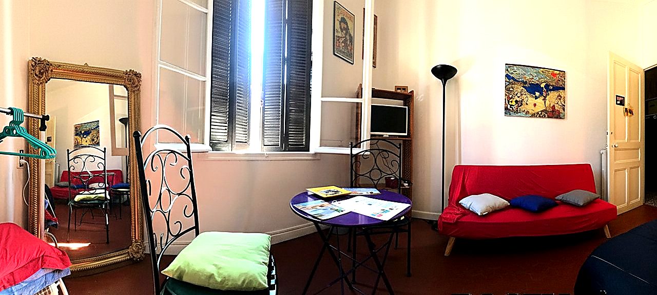 Chambre Double 2 - Bastia Room, vue intérieure avec grand miroir doré, fauteuil rouge et lumière naturelle