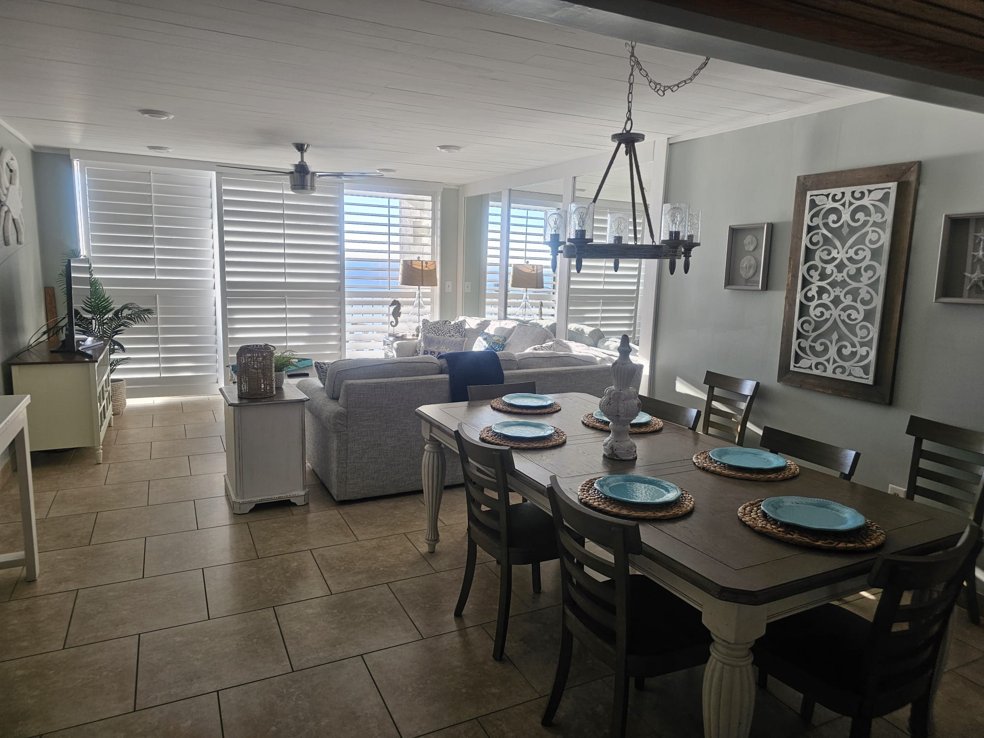 Bright coastal dining and kitchen area with cross-back stools and beach decor
