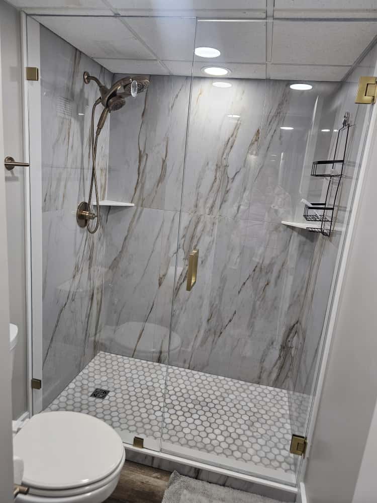 Pristine marble walk-in shower after a deep clean, brass fixtures gleaming