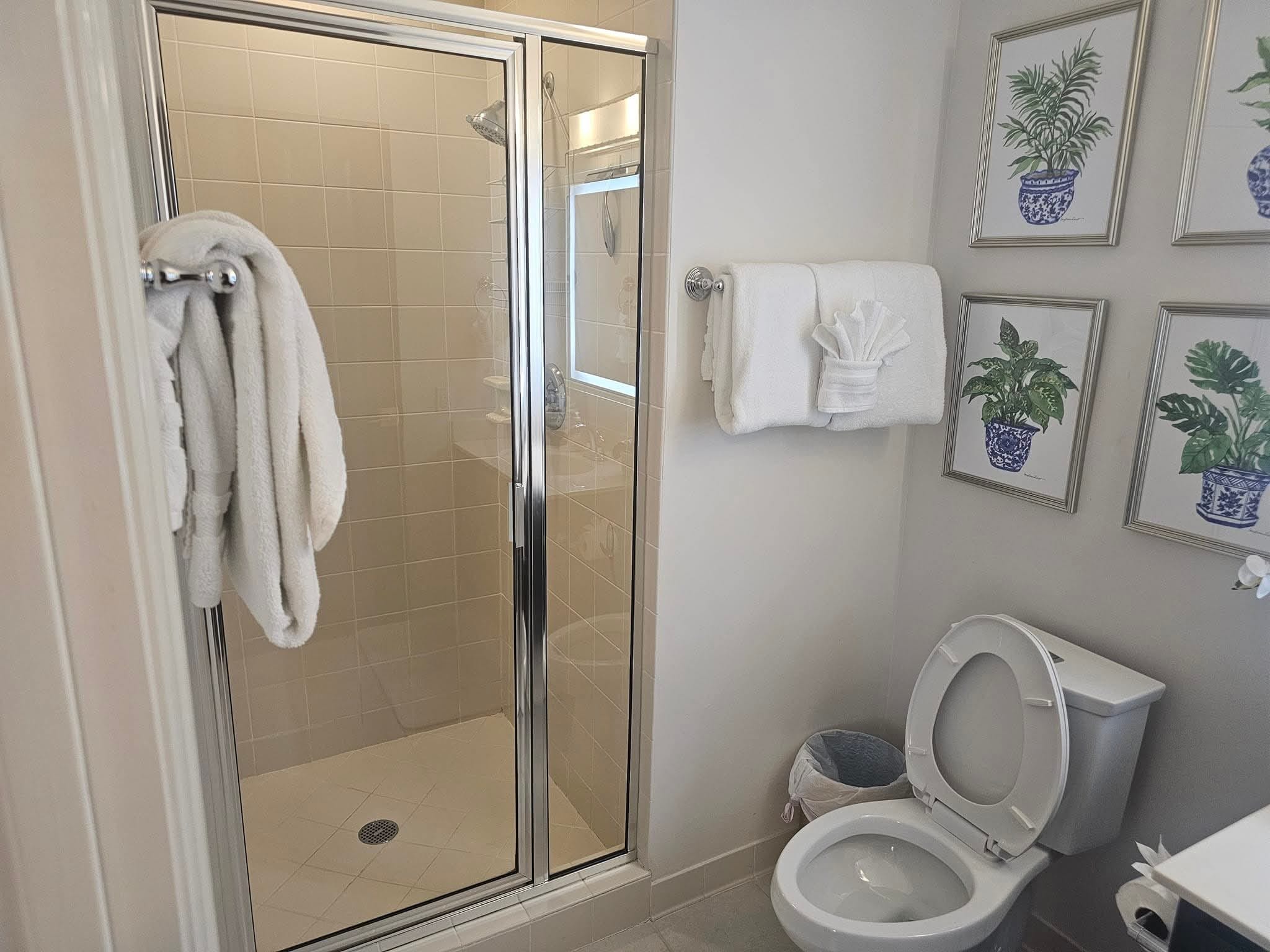 Move-in ready guest bathroom with crisp folded towels and clean shower stall