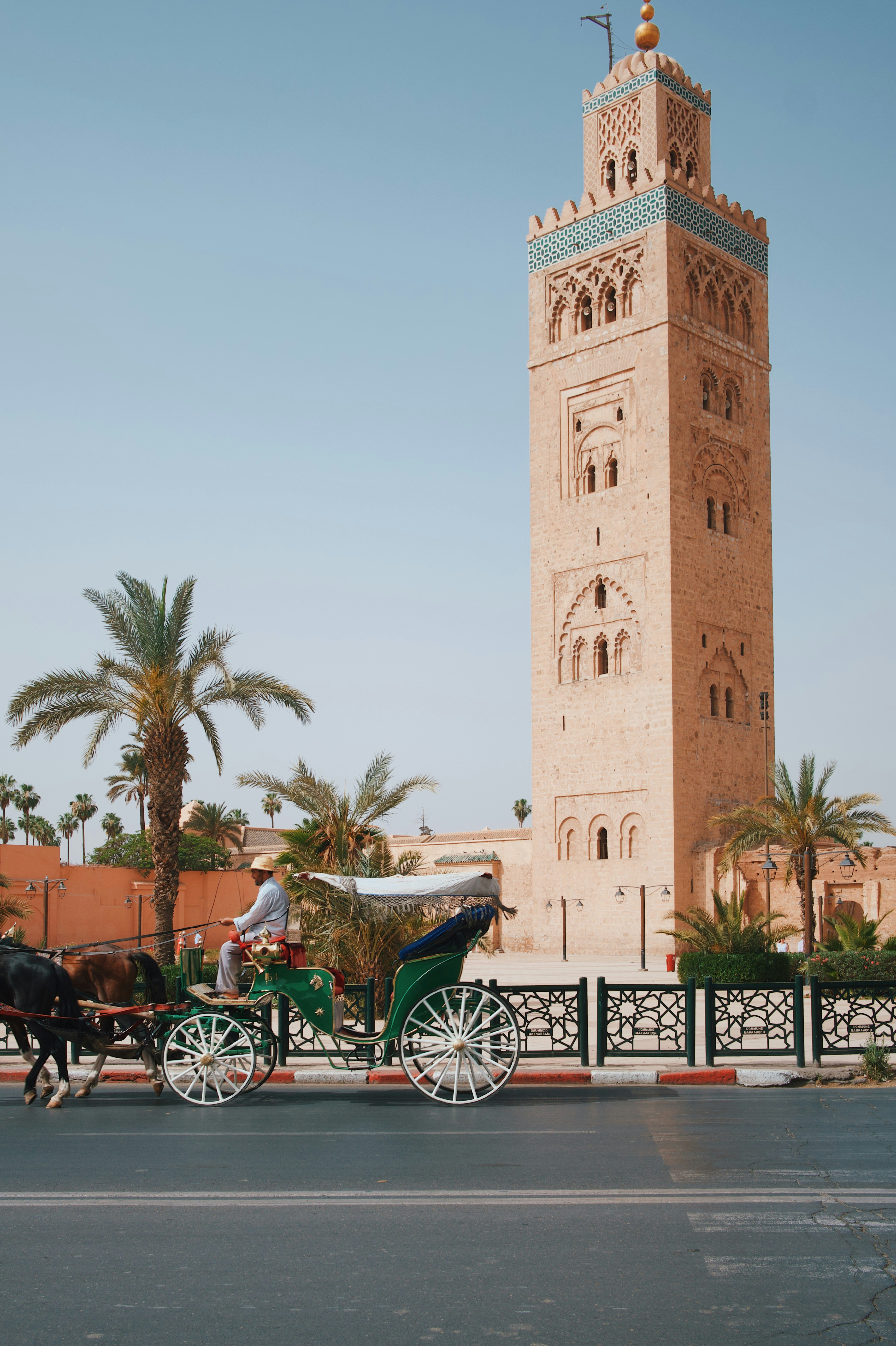 Marrakech con la Koutoubia y un carruaje verde tradicional al atardecer