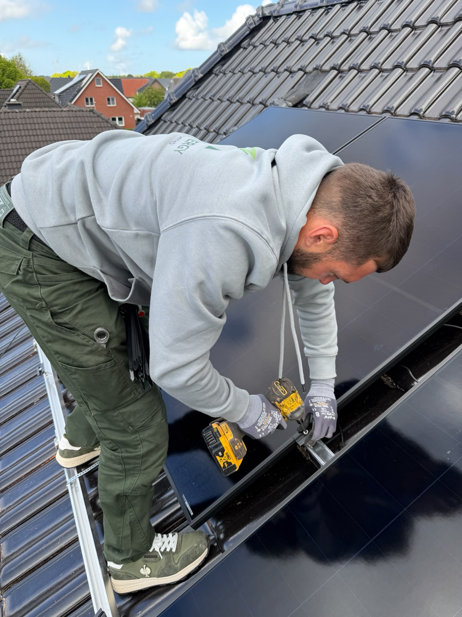 Green Lion Energy Monteur bei der Photovoltaik-Montage auf einem Steildach in der Region Delmenhorst – Full-Black Solarmodule werden fachgerecht verschraubt