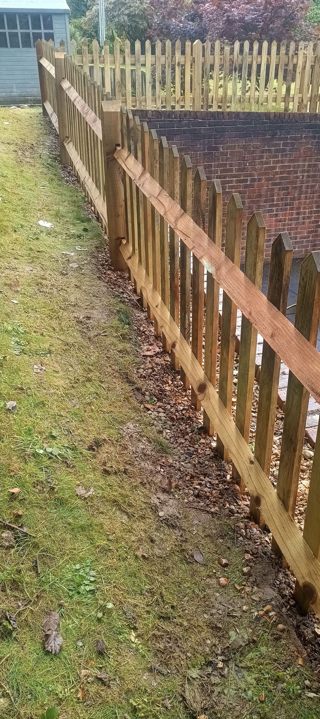 Hand-built picket fence along a brick wall — Sevenoaks