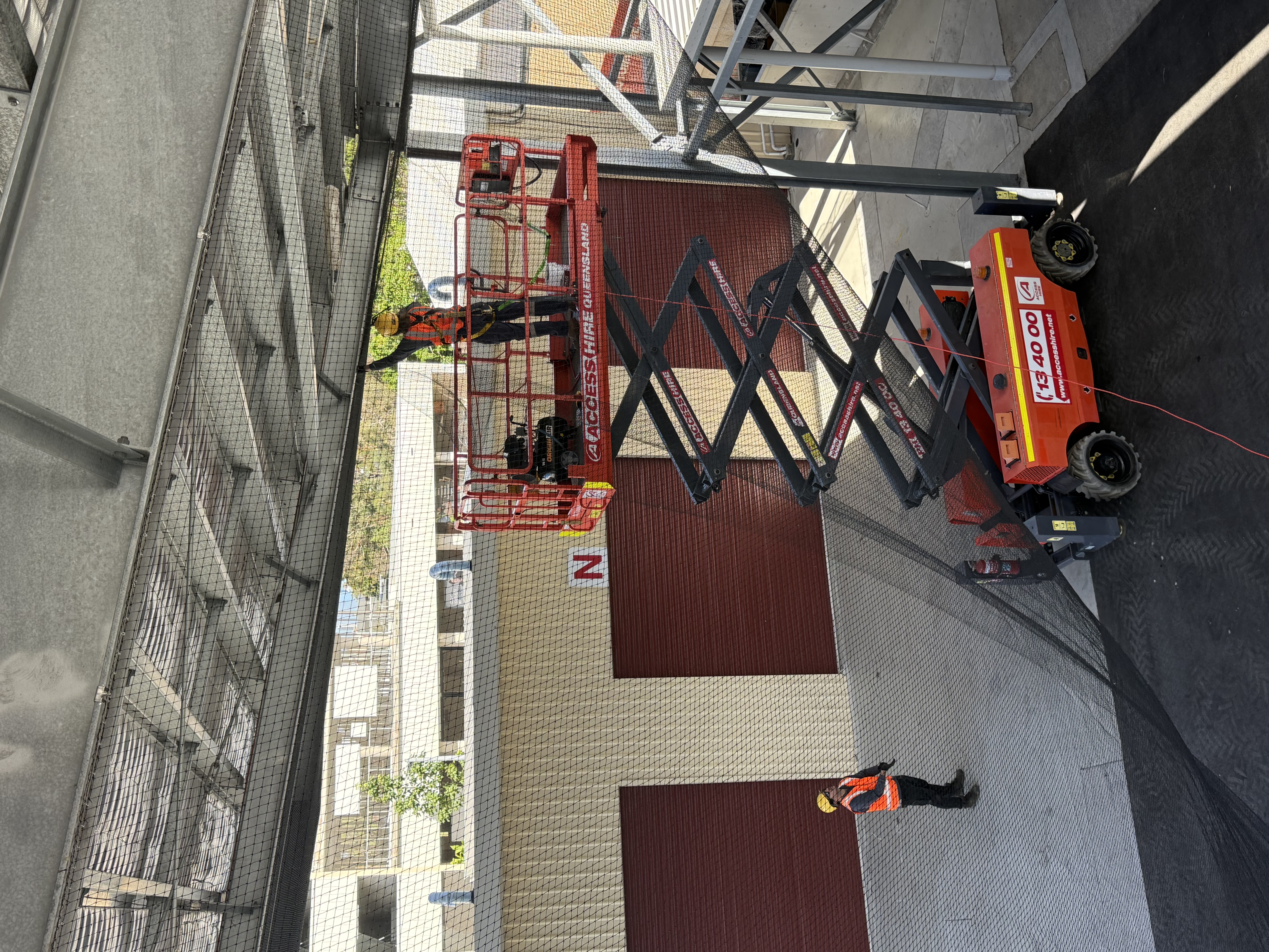 Commercial bird netting installation with scissor lift