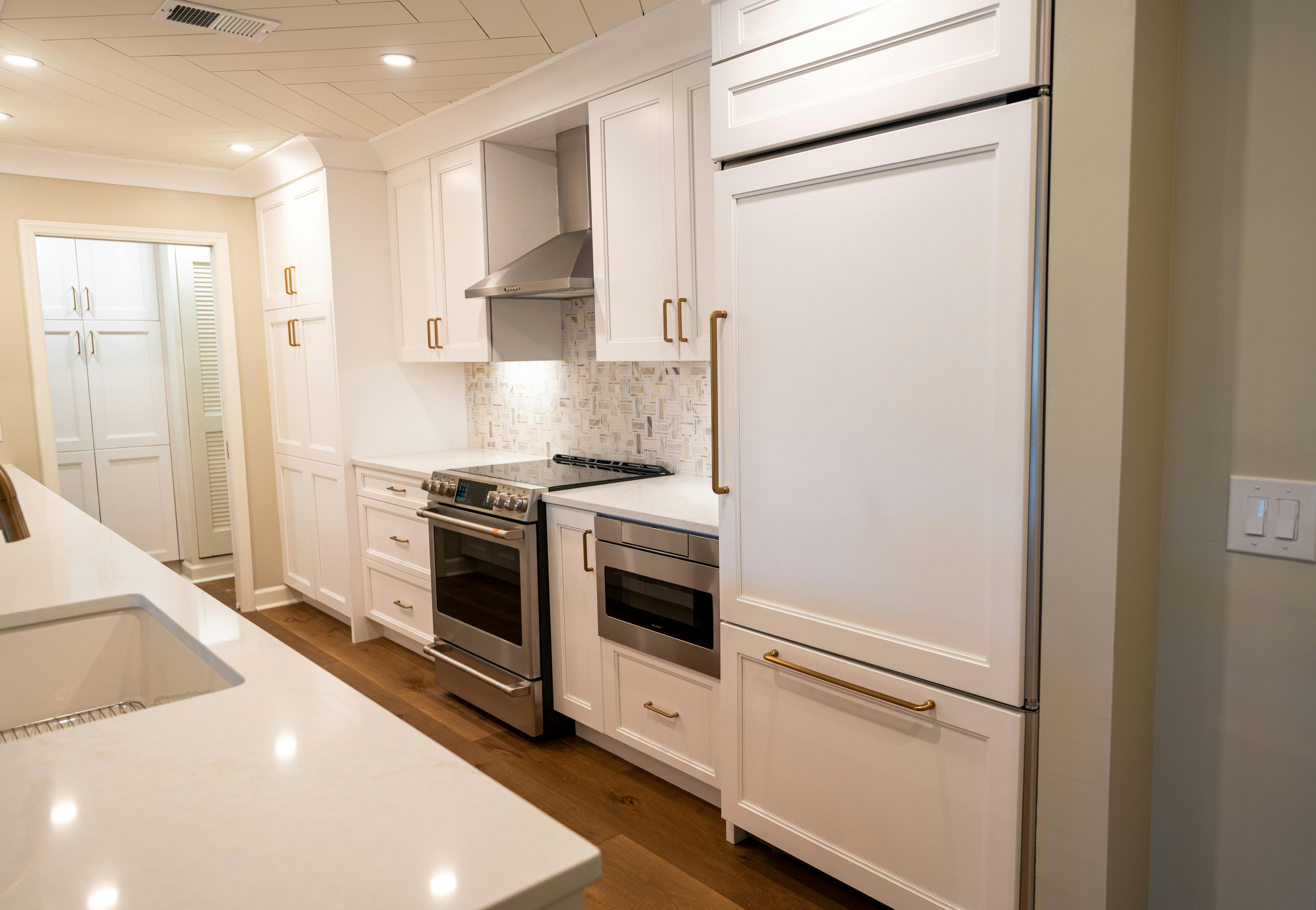 Luxury kitchen with white cabinetry and gold fixtures