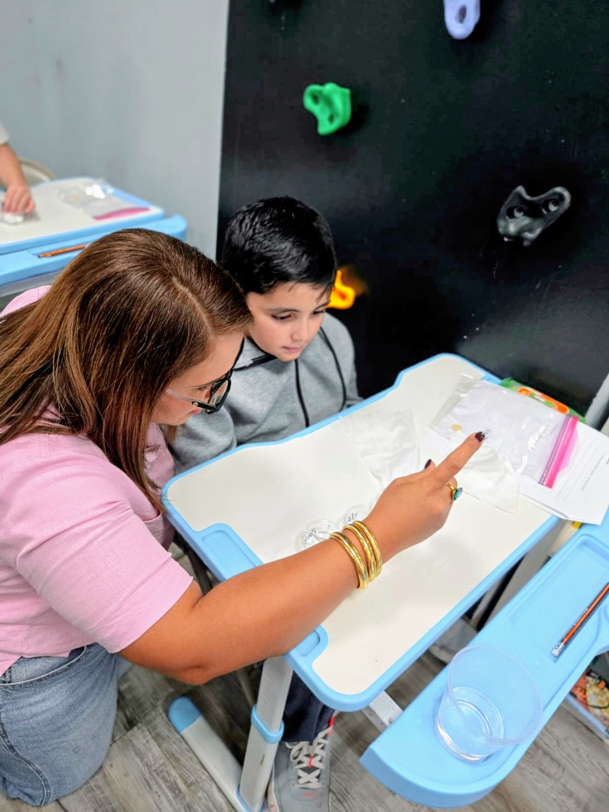 Educadora trabajando uno-a-uno con estudiante en Rise & Shine