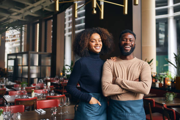 Two small-business owners standing together in their restaurant