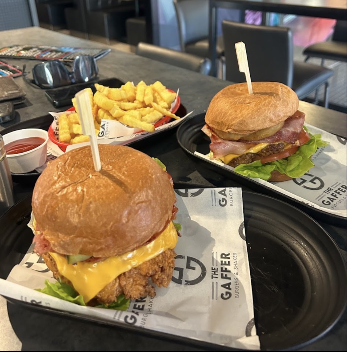 Two Gaffer burgers with a basket of crinkle-cut chips