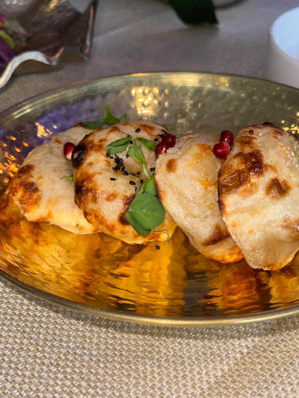 Kulcha on golden platter with pomegranate