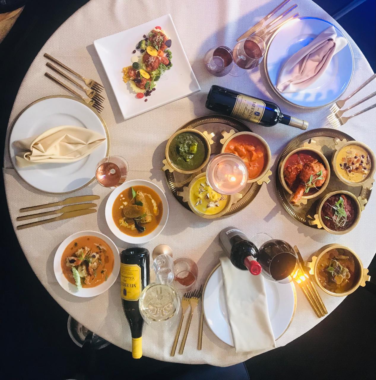 Table spread with curries and wine