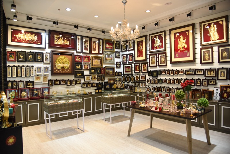 Aarya24KT shop-in-shop interior with chandelier and gold foil wall display