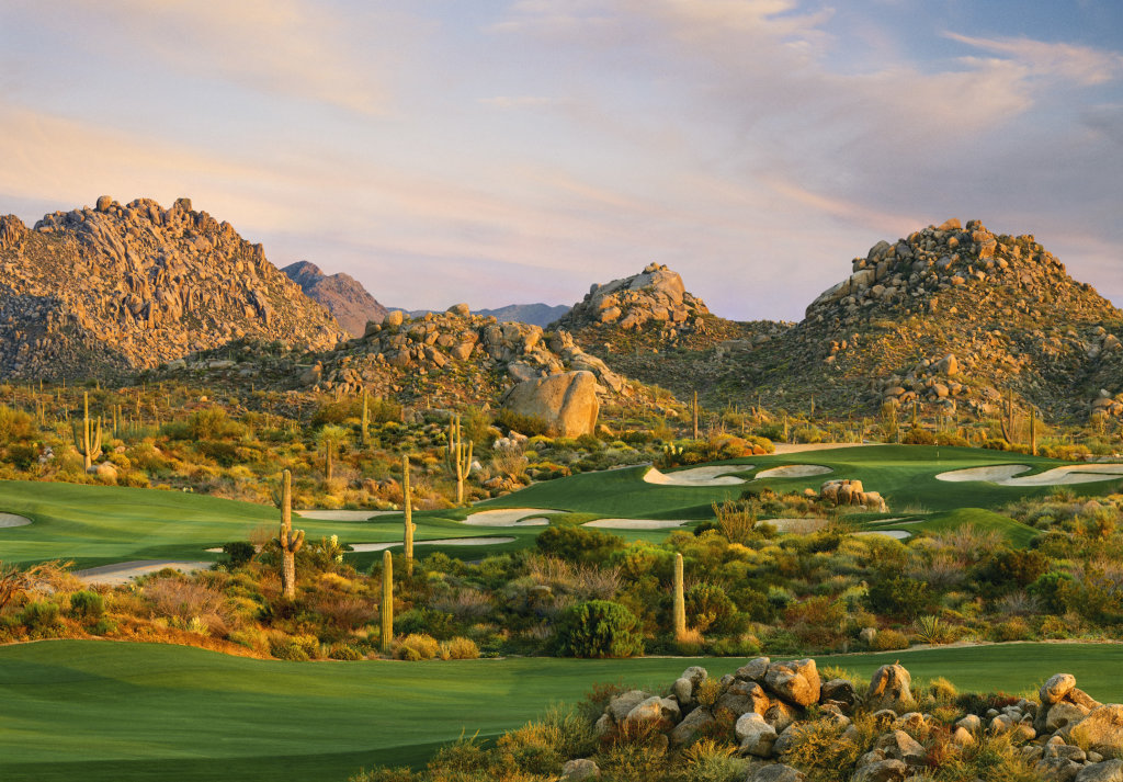Troon North Golf Club at golden hour — granite peaks, saguaros, and a manicured Tom Weiskopf championship green in North Scottsdale, Arizona