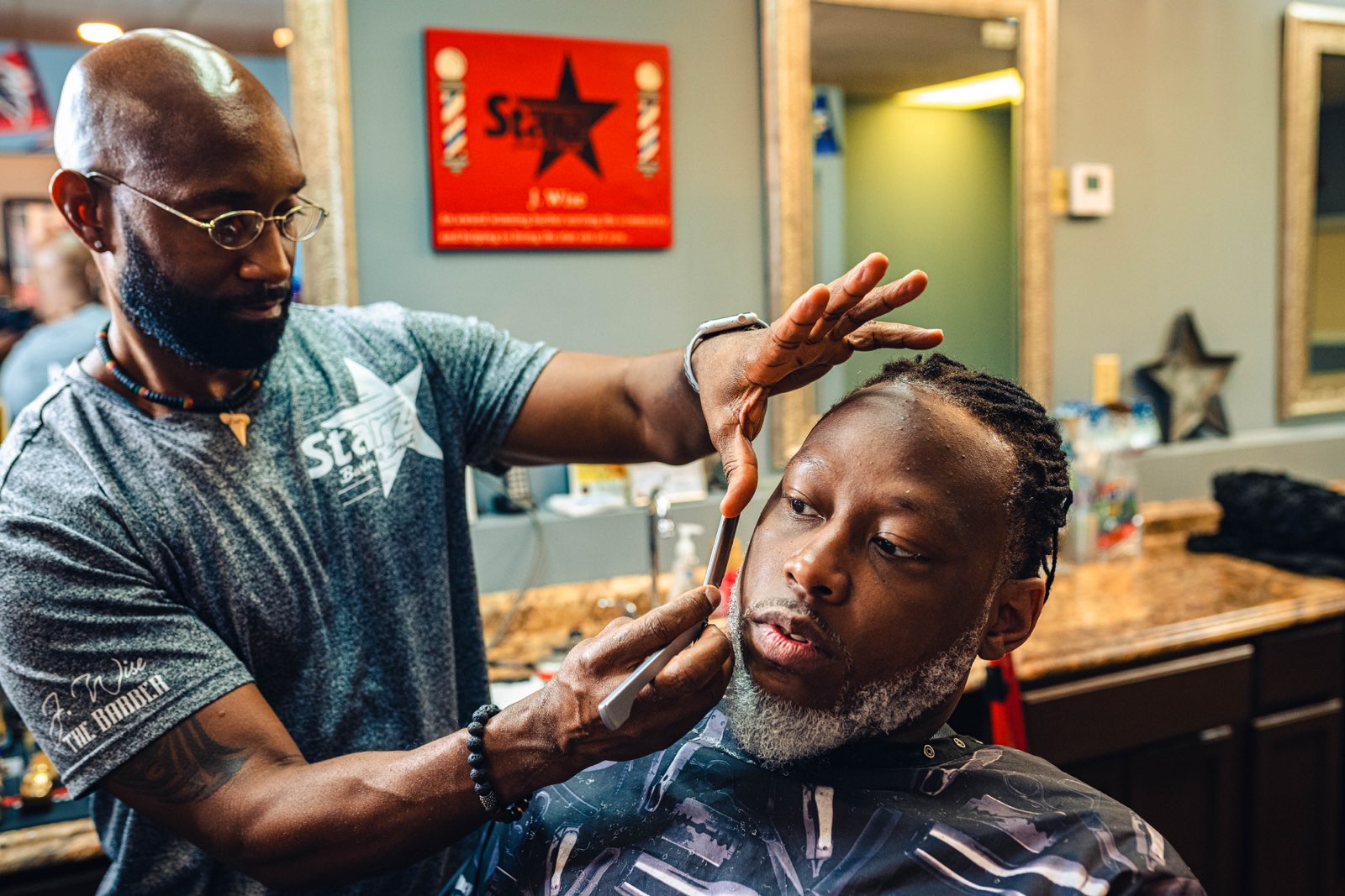J. Wise sculpting a client's beard at Starz