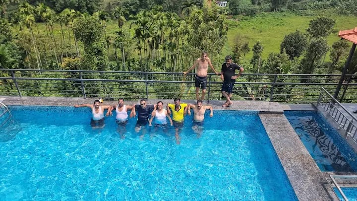 Guddada Siri Homestay scenic swimming pool with guests