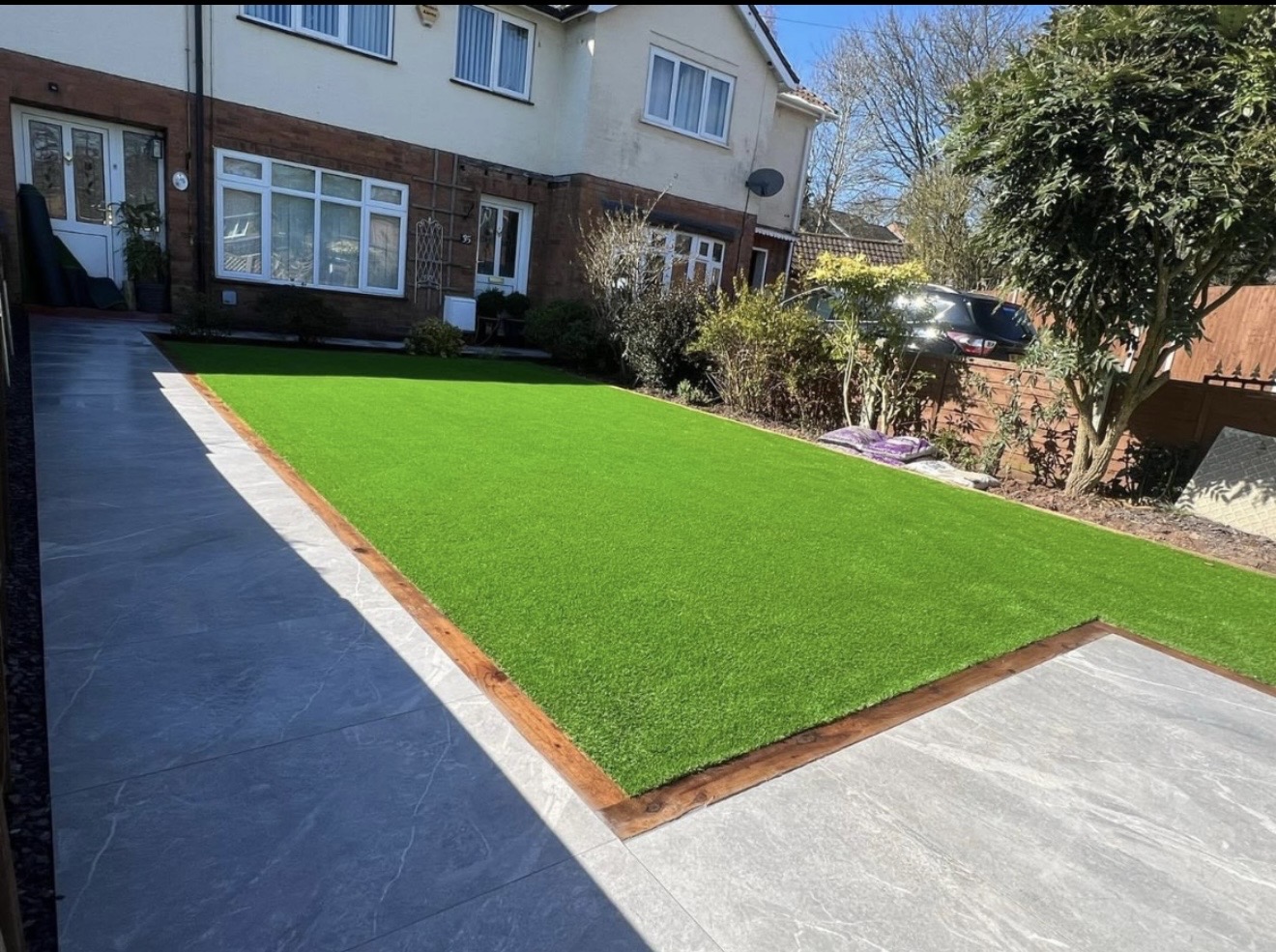 Artificial grass with fencing & porcelain patio