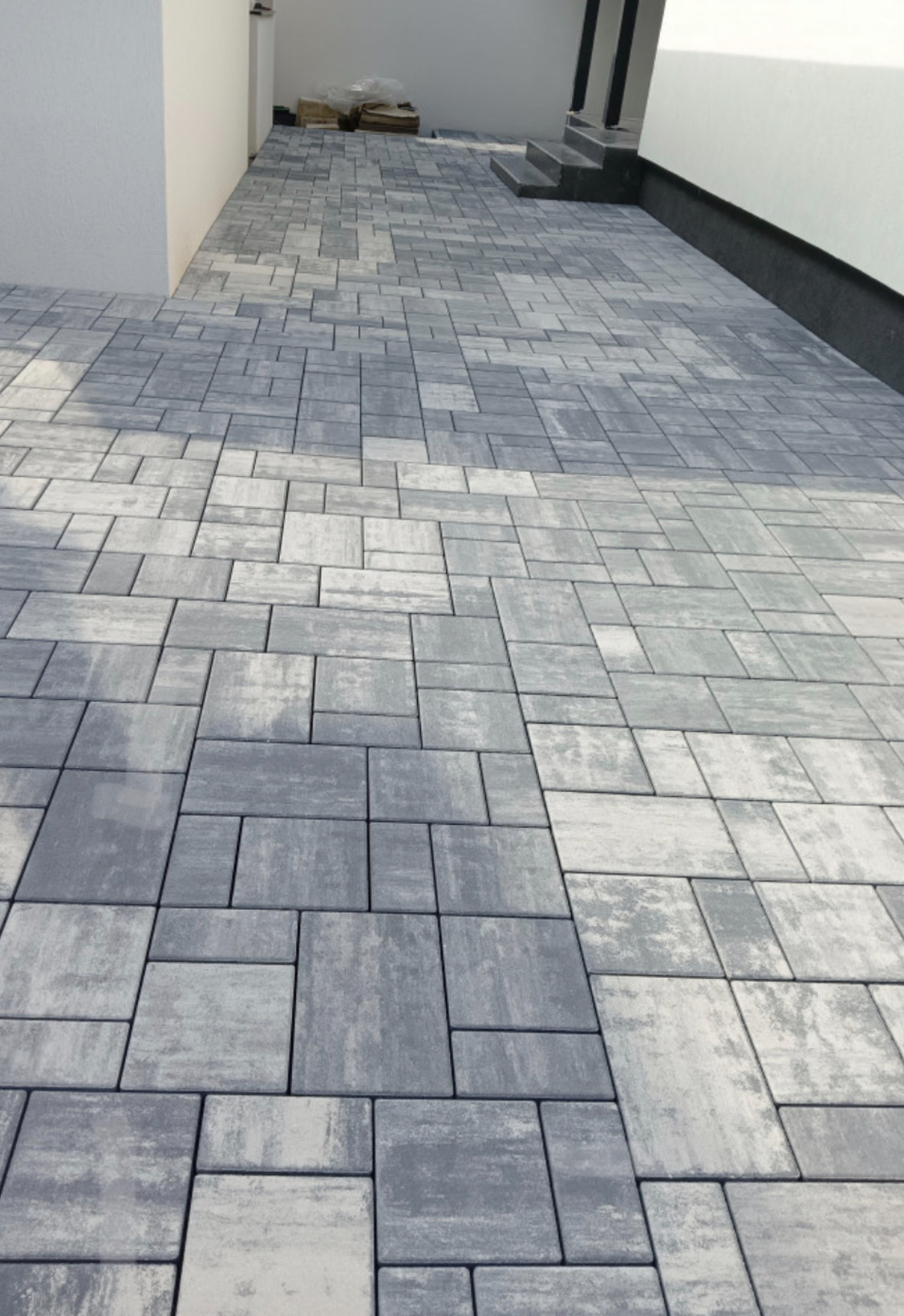 M&L Exterior Design — Modern ashlar grey paver installation on a luxury home patio