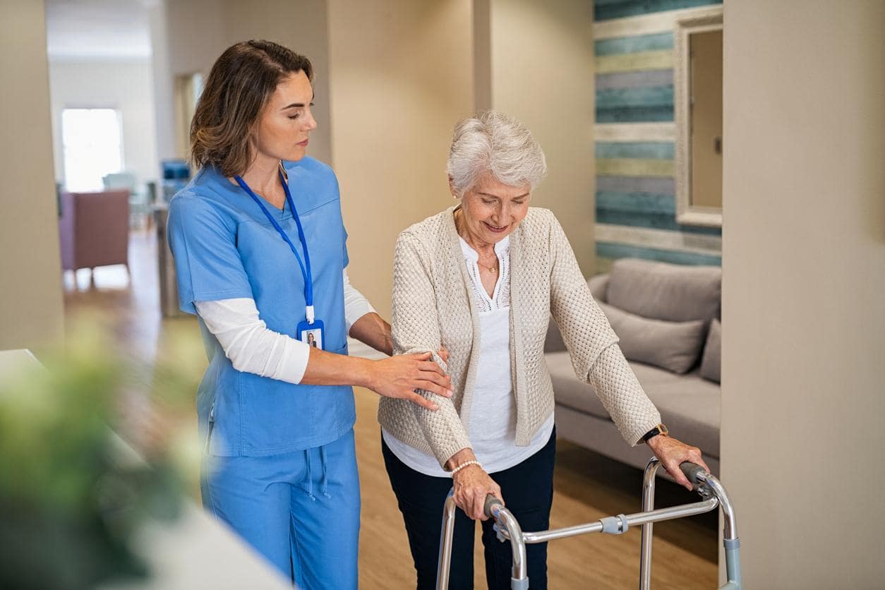 Home Health Care - Certified nursing assistant helping senior woman