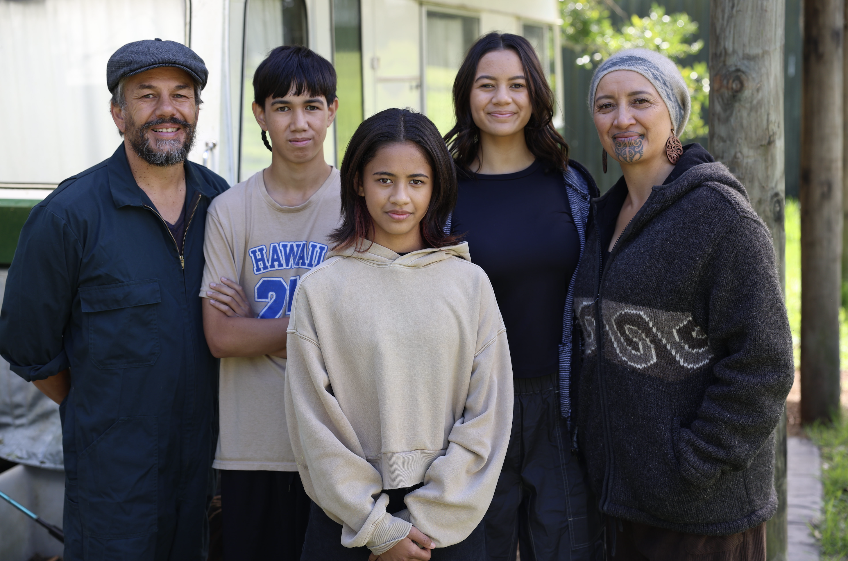 Quinton Hita with his whānau outside their whare in Te Tai Tokerau