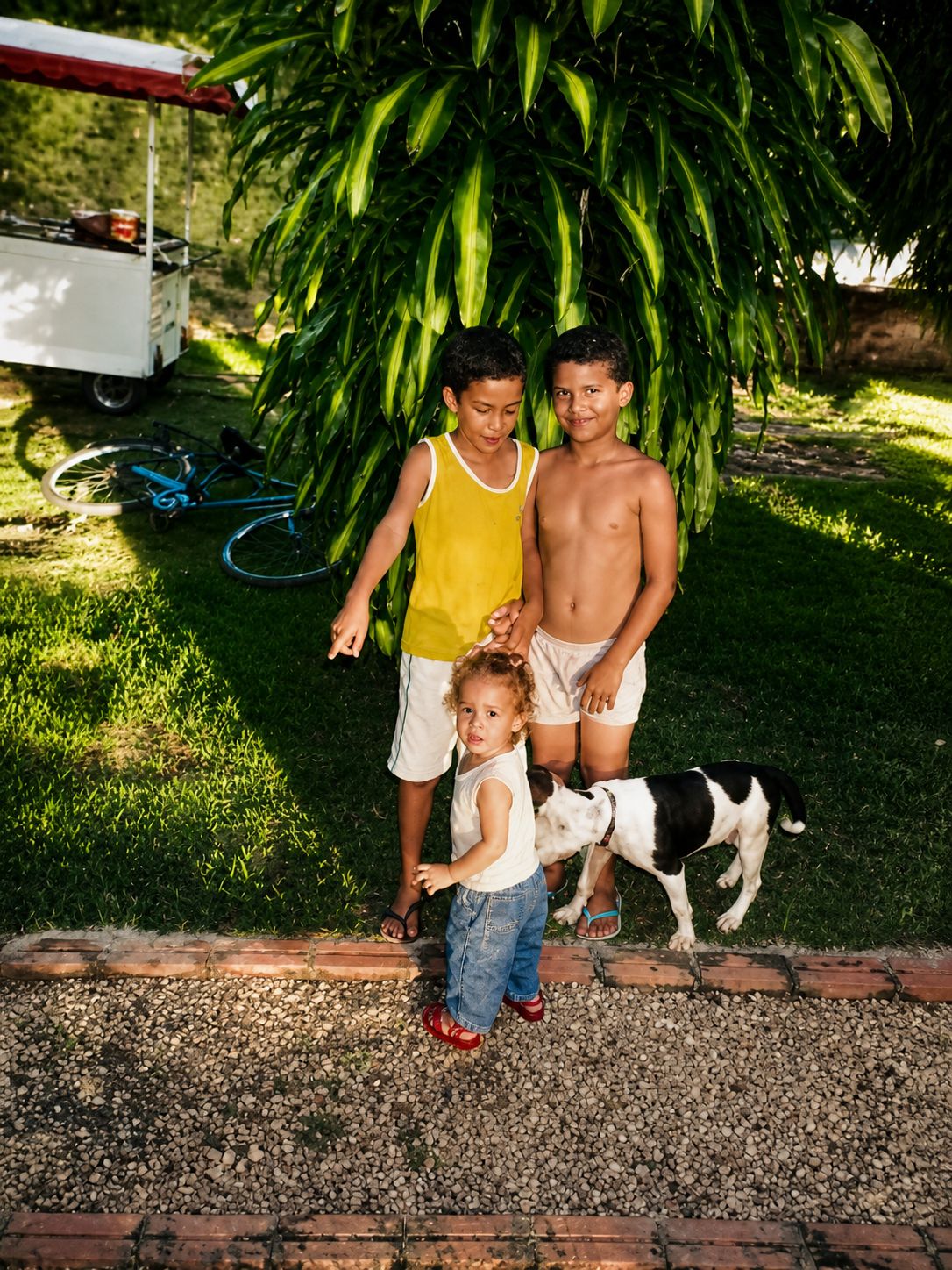 Crianças brincando, o carrinho ao fundo