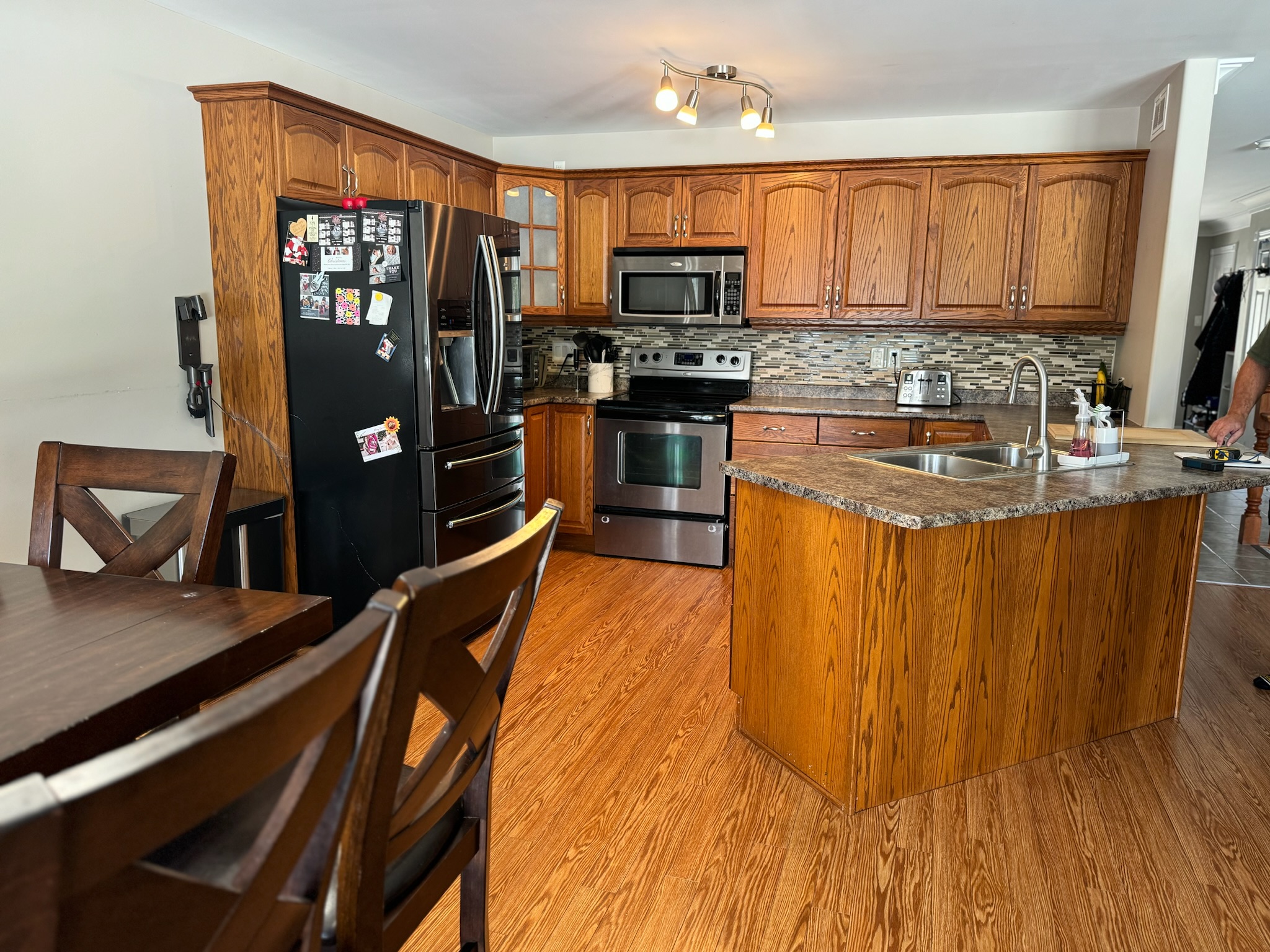 Before refinish — Cathedral oak → warm greige shaker · cabinetry extended to the ceiling