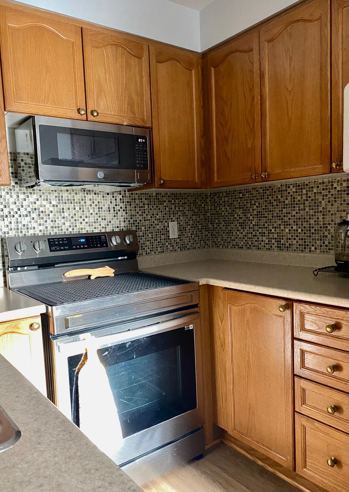 Before refinish — Cathedral oak → white shaker, black hardware