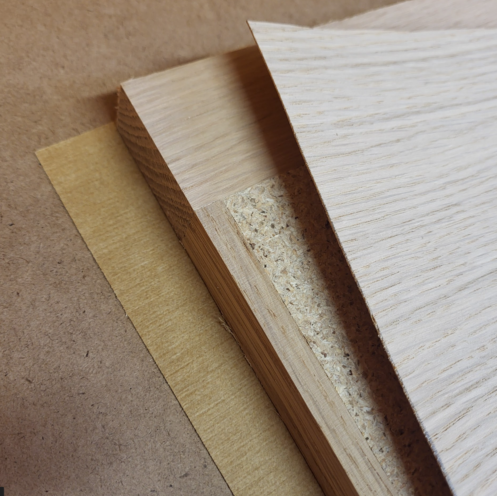 Premium Veneer cabinet door cross-section — solid wood edge, particle core, vacuum-pressed veneer face
