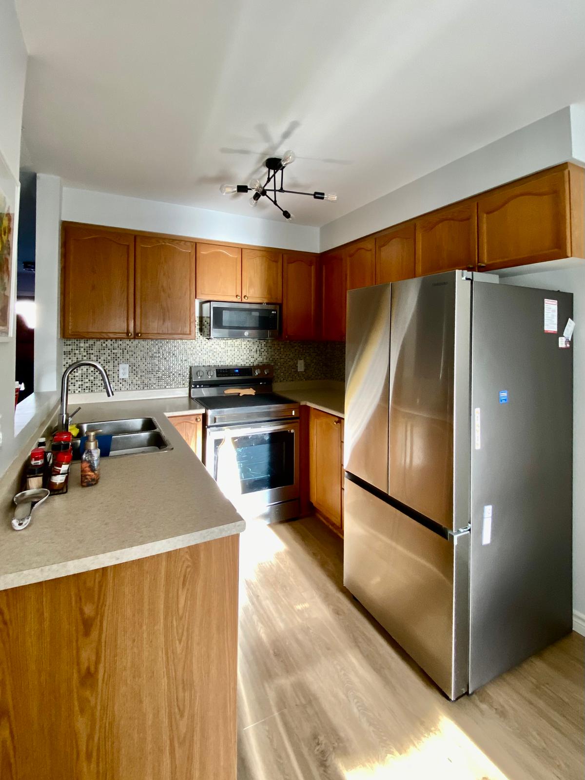 Before refinish — Cathedral oak → white shaker, black hardware