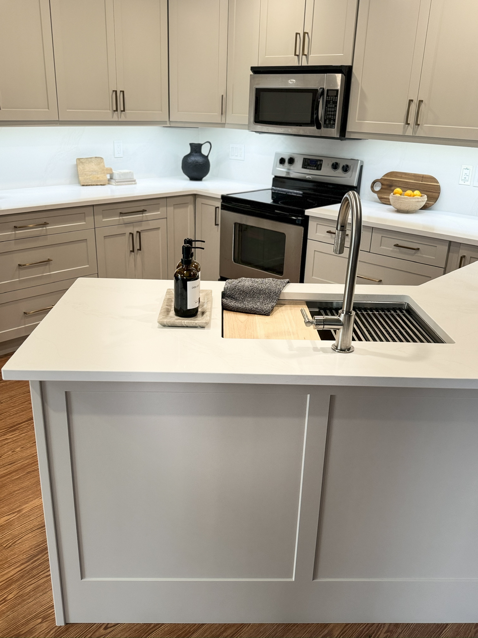 After refinish — Cathedral oak → warm greige shaker · cabinetry extended to the ceiling