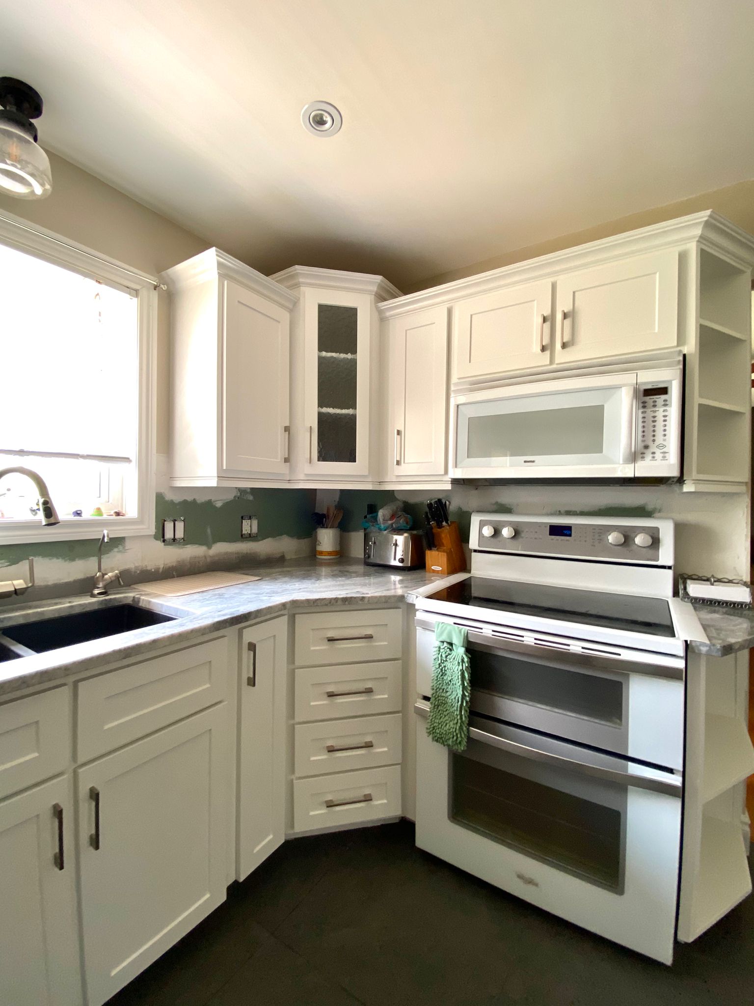After refinish — Cathedral oak → white shaker (mid-reno)