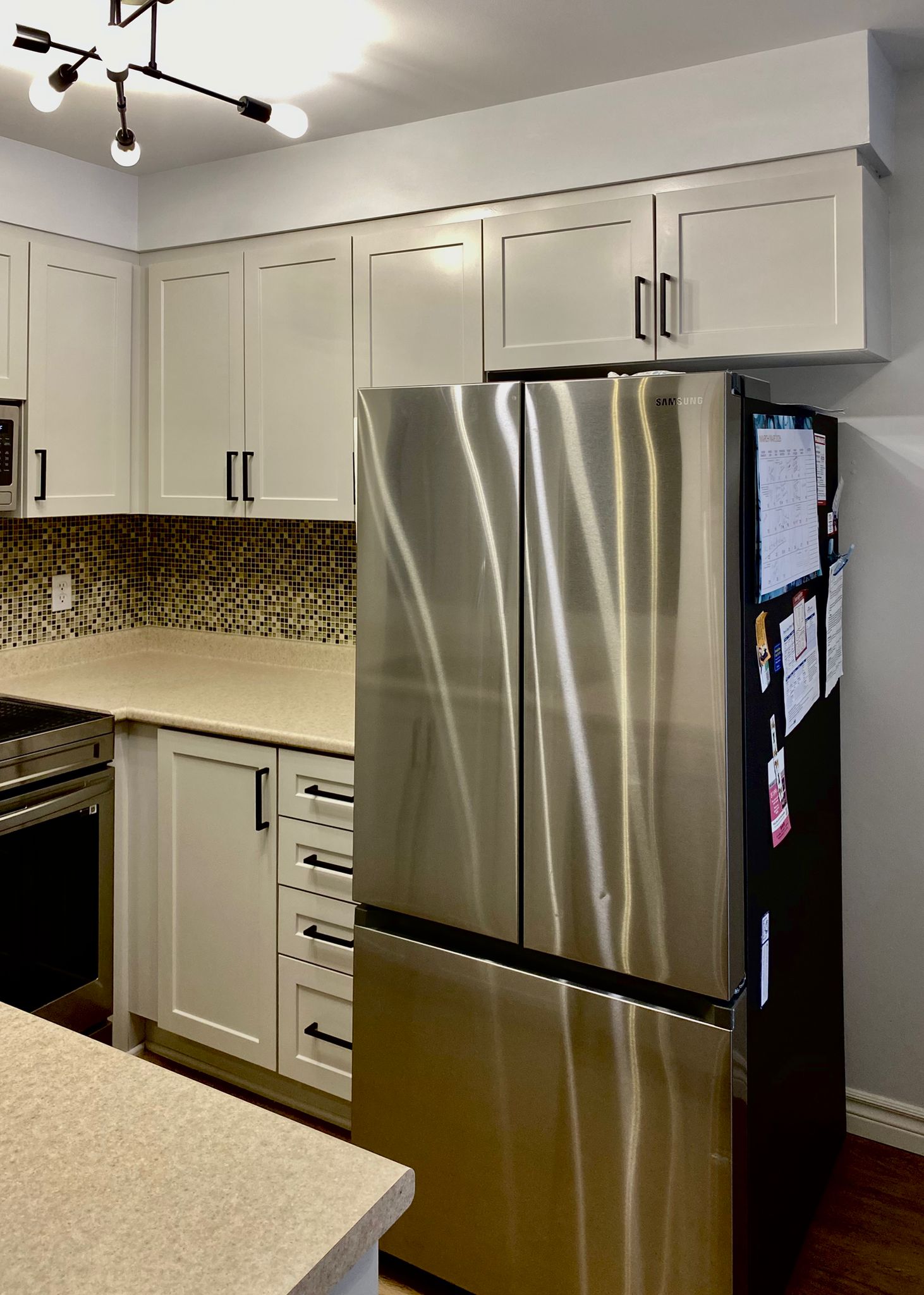 After refinish — Cathedral oak → white shaker, black hardware