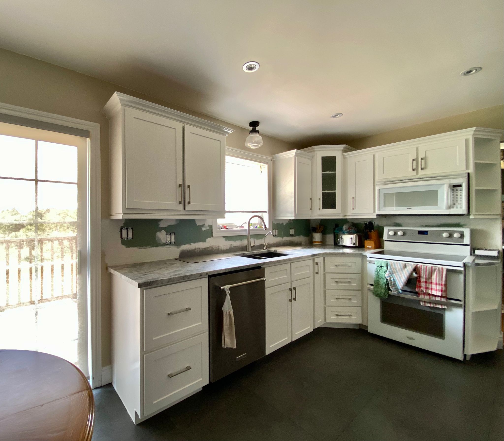After refinish — Cathedral oak → white shaker (mid-reno)