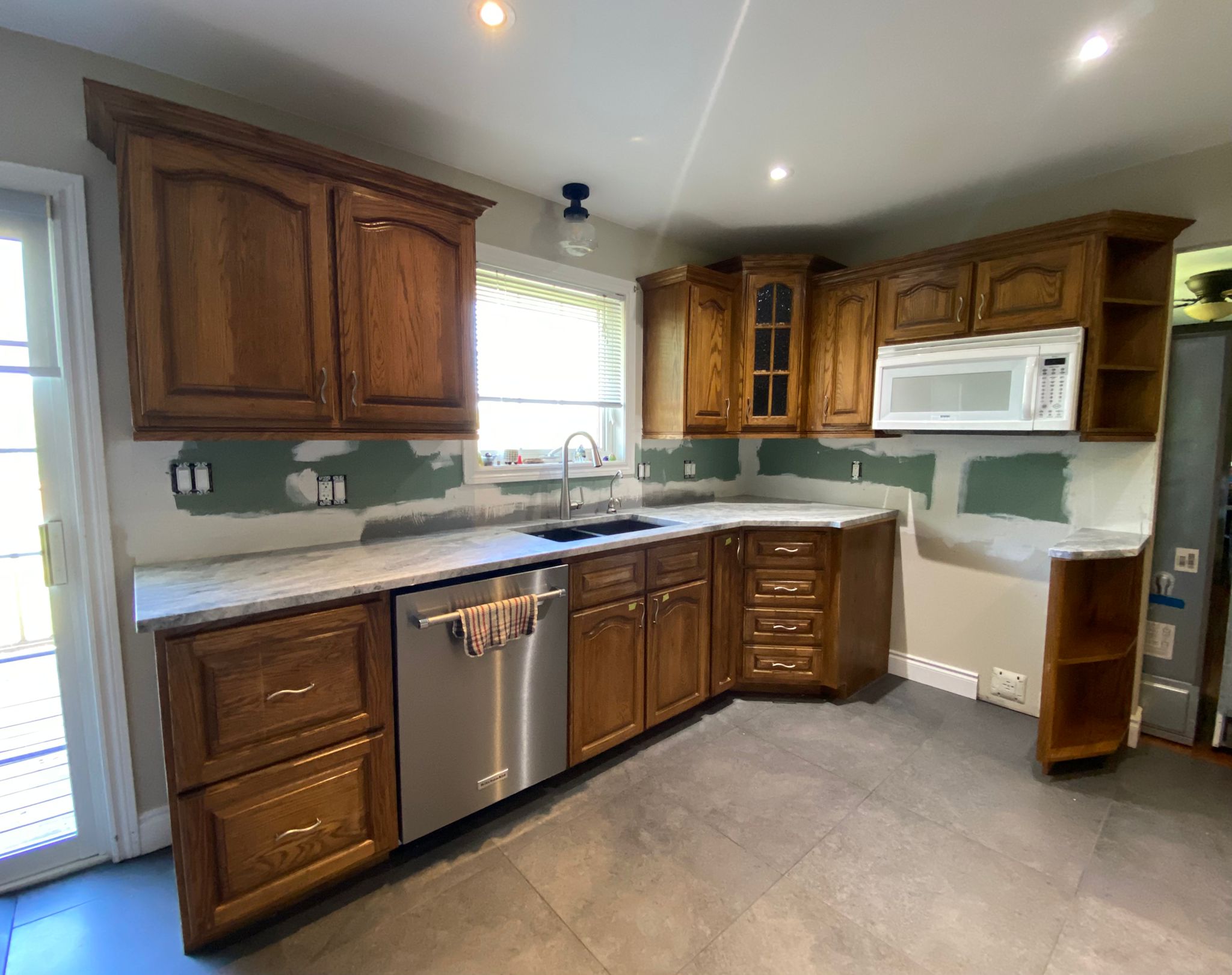 Before refinish — Cathedral oak → white shaker (mid-reno)