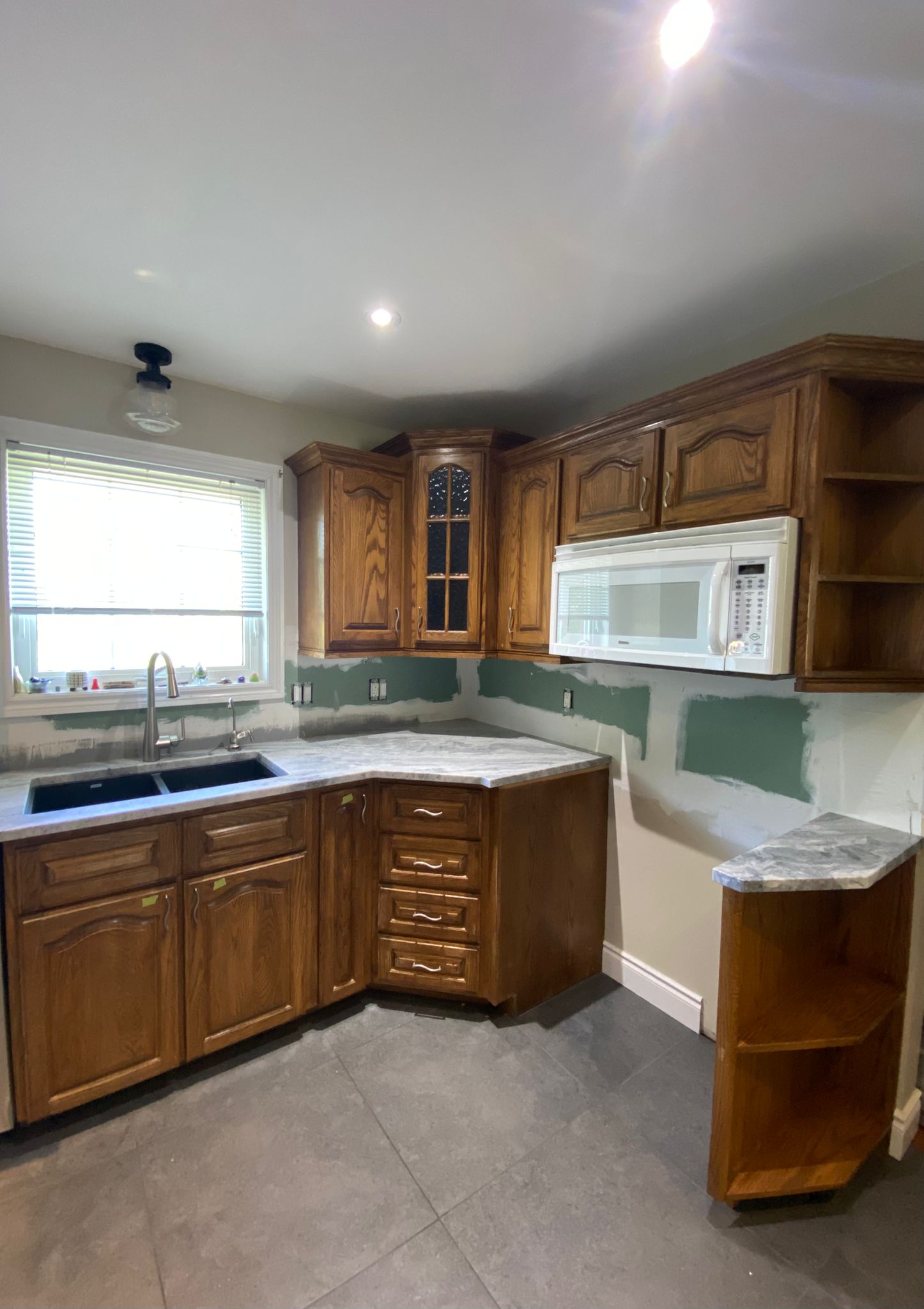 Before refinish — Cathedral oak → white shaker (mid-reno)
