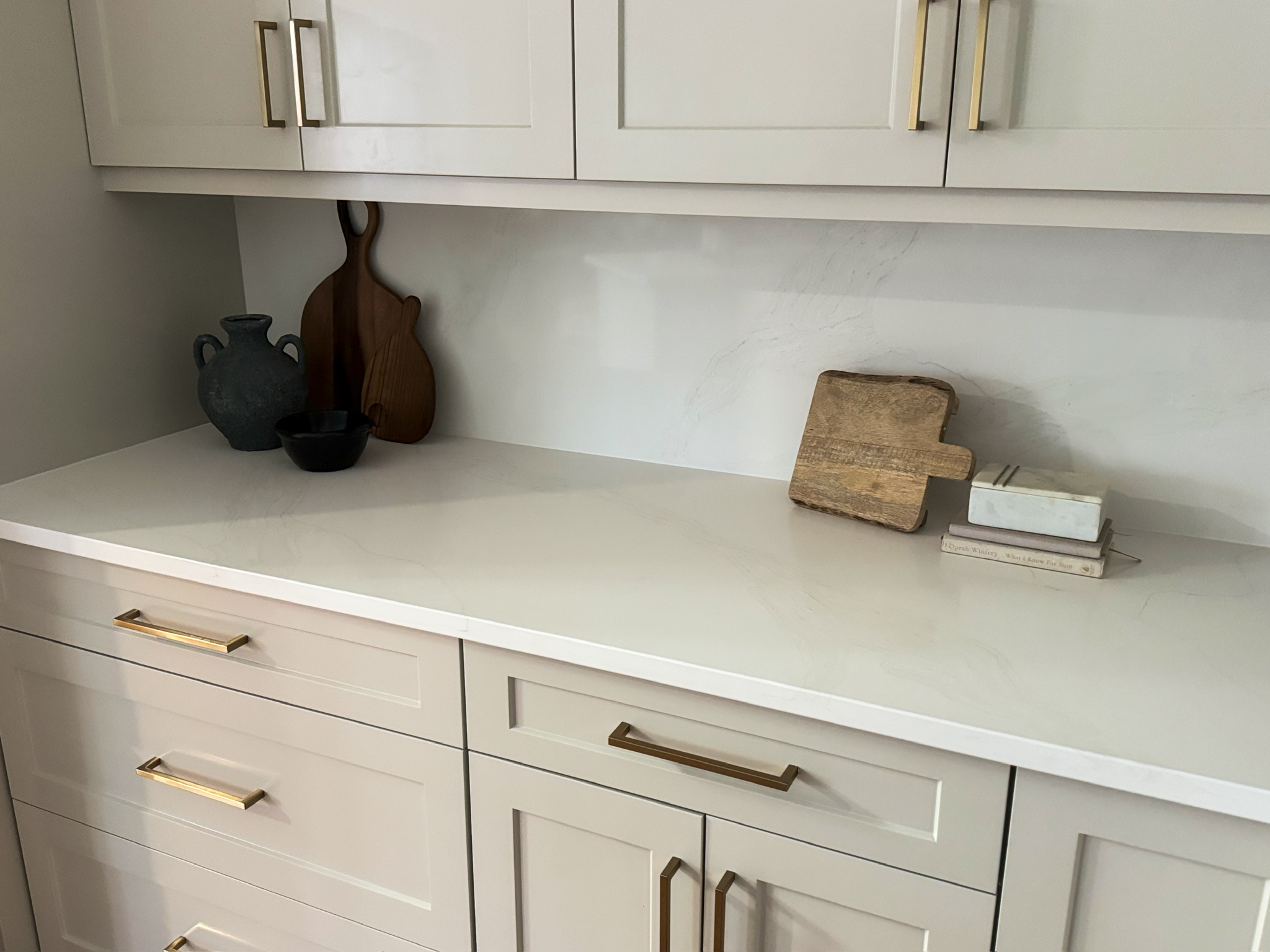 After refinish — Cathedral oak → warm greige shaker · cabinetry extended to the ceiling