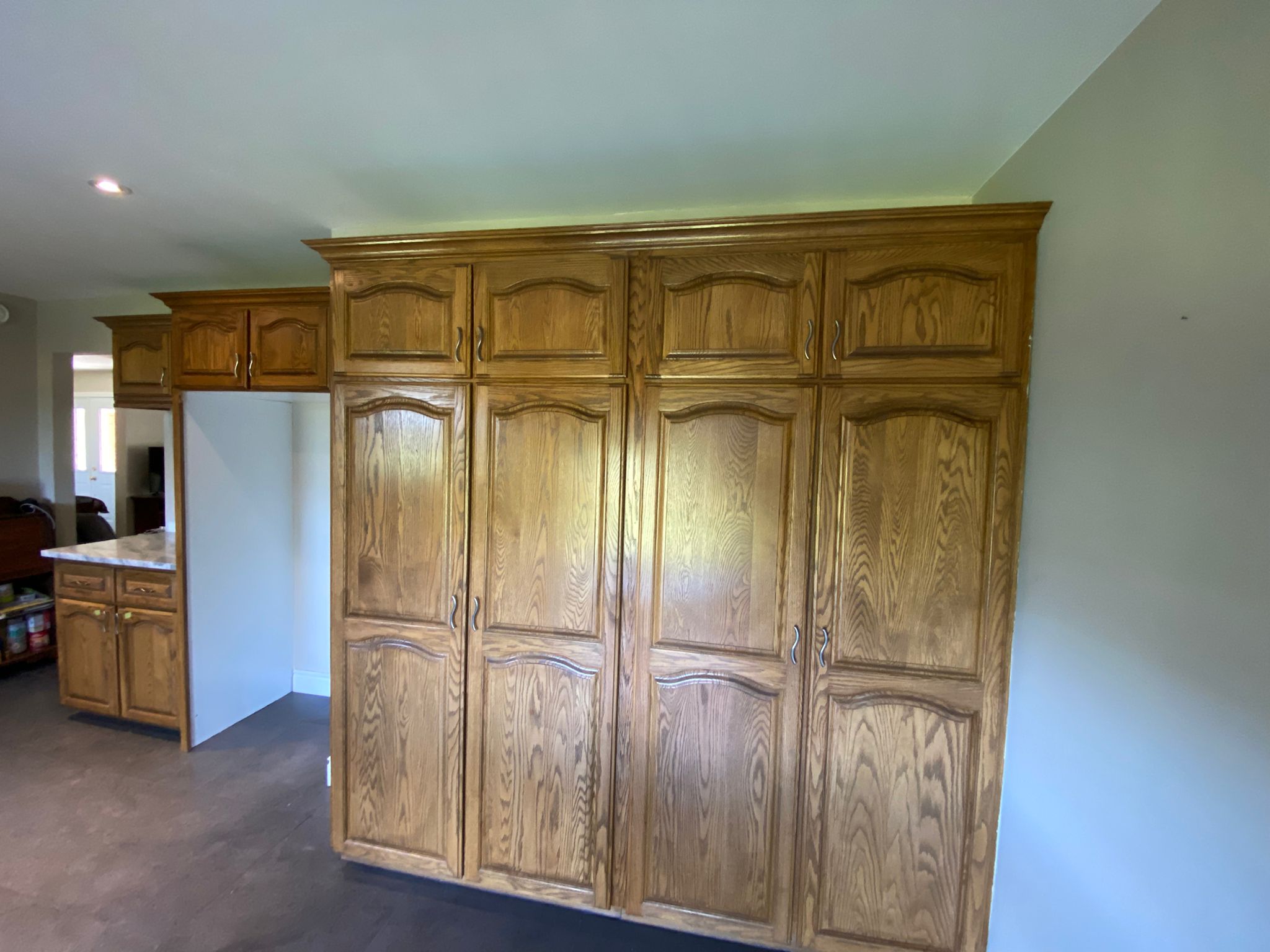 Before refinish — Cathedral oak → white shaker (mid-reno)
