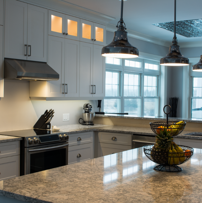 Belmont Custom Cabinetry โ white Shaker kitchen with industrial pendants and granite island
