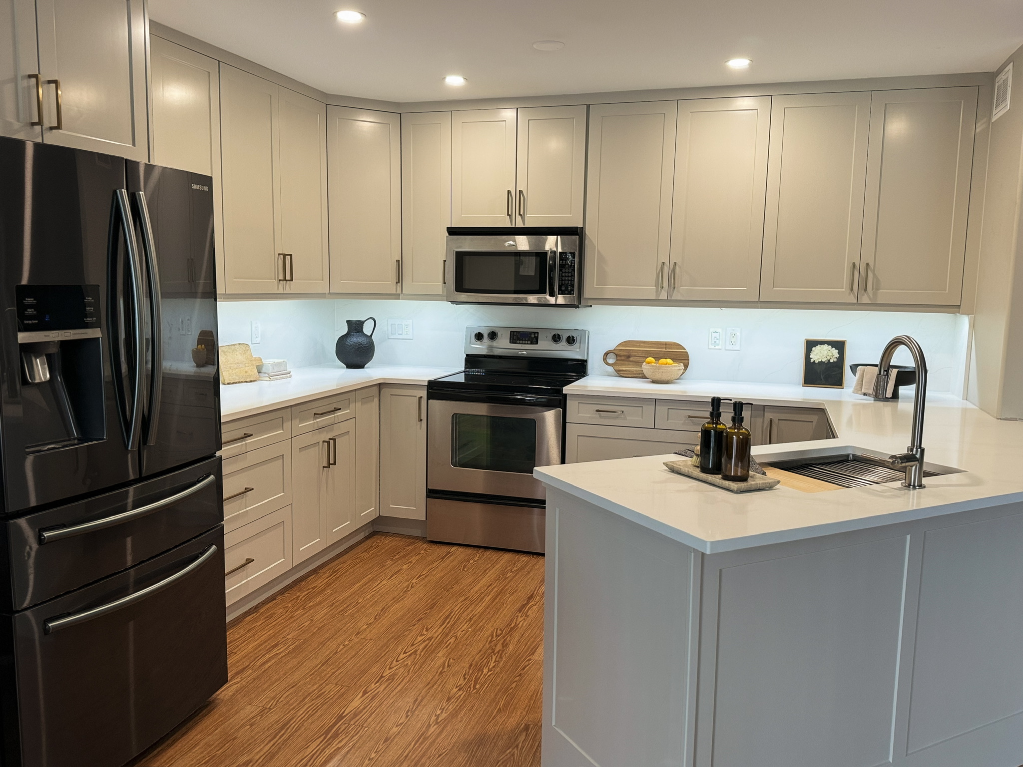 After refinish — Cathedral oak → warm greige shaker · cabinetry extended to the ceiling