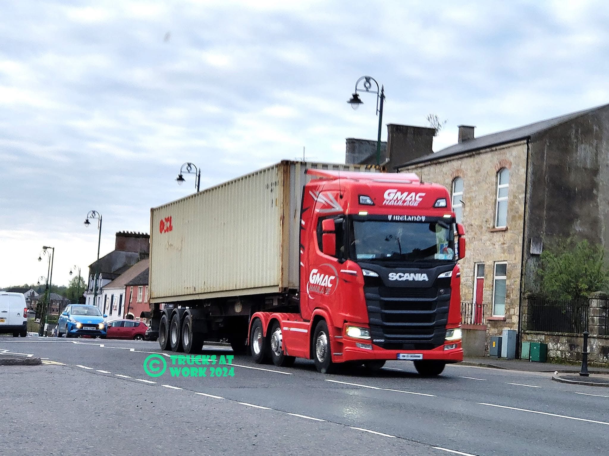 GMAC Haulage red Scania pulling an OOCL container through an Irish town
